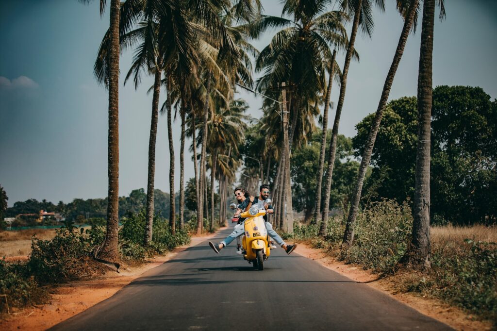 Zwei glückliche Personen auf einem gelben Roller in Goa